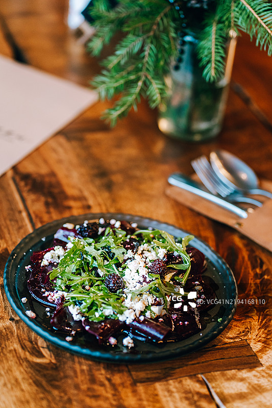 木桌上的甜菜沙拉，配有芝麻菜、黑莓、松子和羊奶酪图片素材