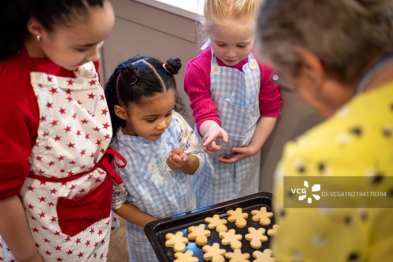 奶奶给孩子们送上新鲜出炉的饼干图片素材