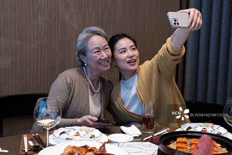 祖母和孙女在餐桌上自拍图片素材