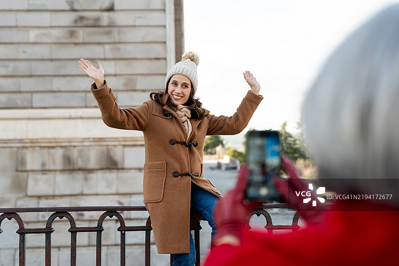 冬季在城市观光时，女性摆姿势拍照图片素材