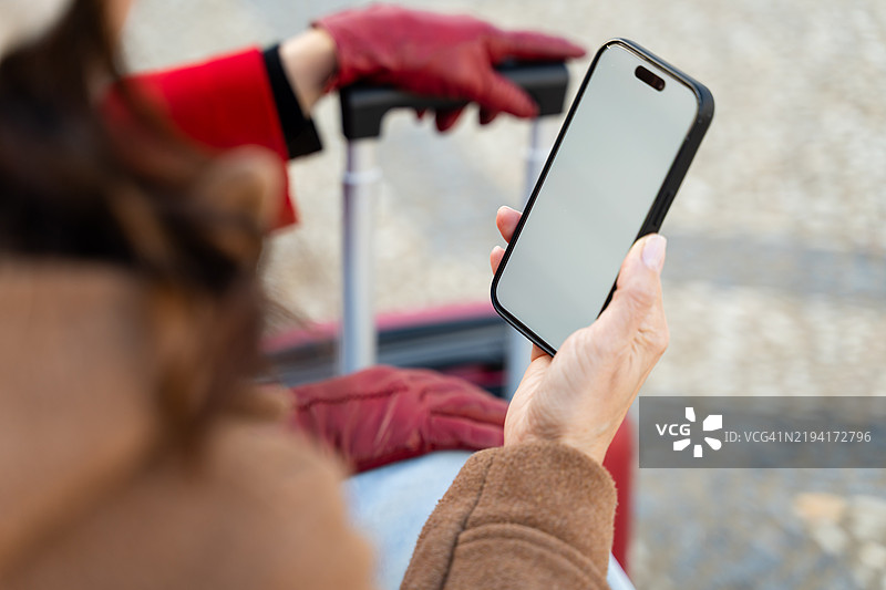 女商人在等待出租车时使用智能手机图片素材