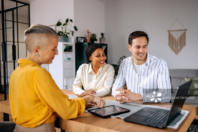 女性理财顾问在家中与一对夫妇交谈图片素材