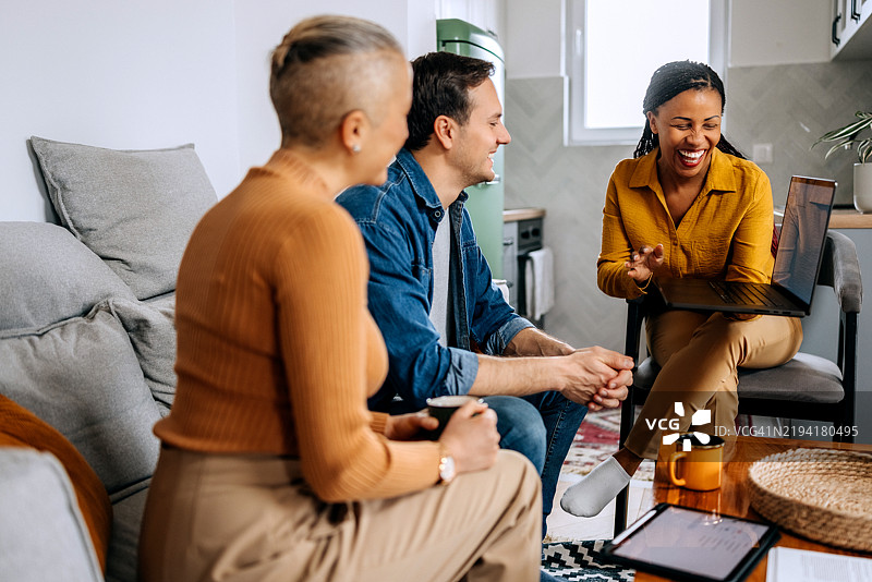 微笑的女性理财顾问在年轻夫妇的公寓里交谈图片素材