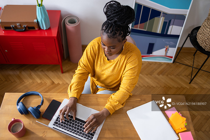 年轻的黑人女性在家用笔记本电脑工作图片素材