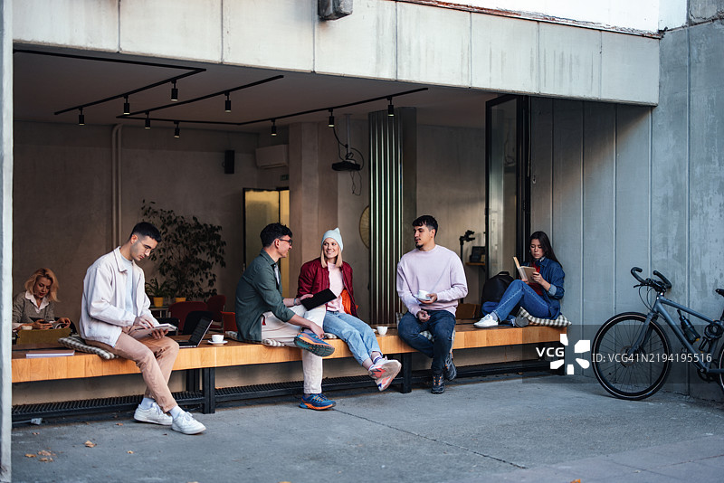 一群朋友在现代咖啡馆外放松和社交图片素材