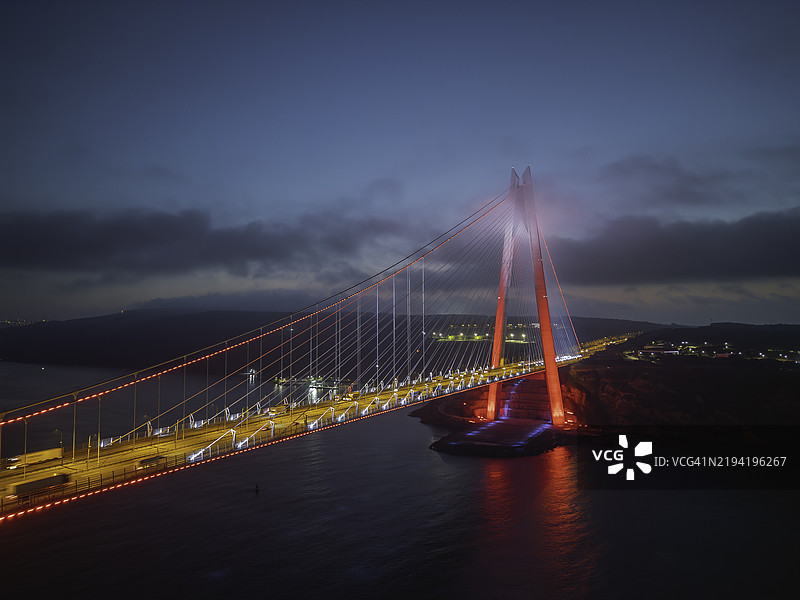 伊斯坦布尔的日落：货船在日出时经过雅武兹·苏尔坦·塞利姆大桥图片素材