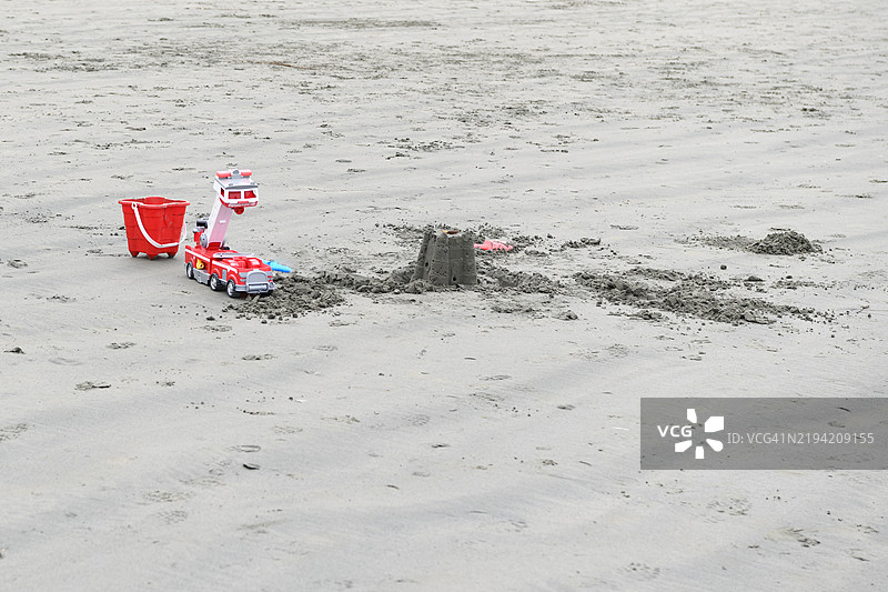 特写塑料玩具消防车、铲子、桶和沙堡，位于加拿大不列颠哥伦比亚省温哥华岛托菲诺的沙滩上图片素材