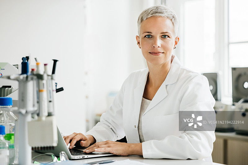 微笑的女性科学家在明亮的实验室工作肖像图片素材