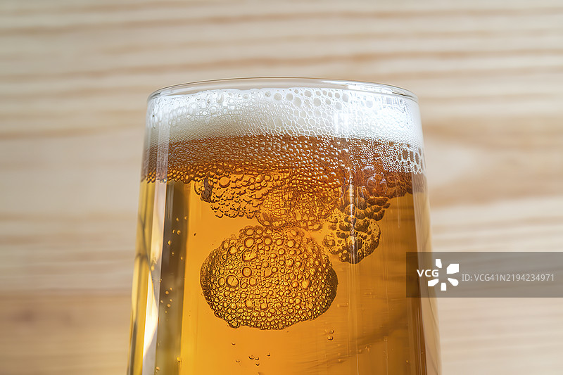 一杯装满金色啤酒的玻璃，气泡上升到表面图片素材