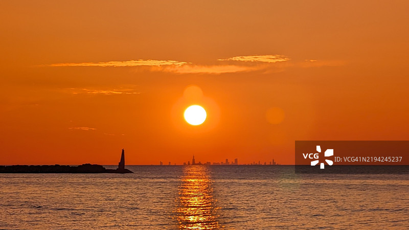 密歇根城，印第安纳州，美国，橙色天空下的海景图片素材