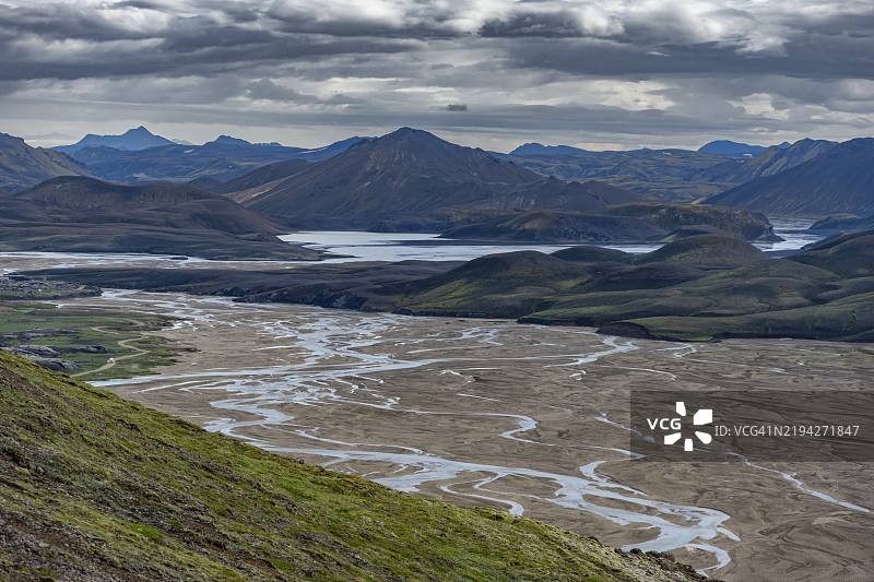 在火山景观中蜿蜒流淌的河流，背景是山脉，地点：兰德曼纳劳卡，菲亚尔拉巴克自然保护区，冰岛高地，南部冰岛，欧洲图片素材