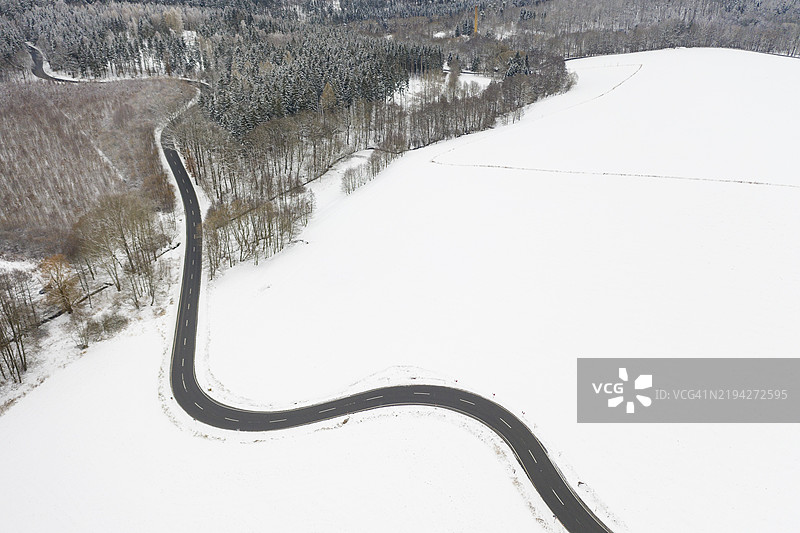 德国中萨克森州，埃彭多夫与莱布斯多夫之间的雪中蜿蜒乡村道路的鸟瞰图图片素材