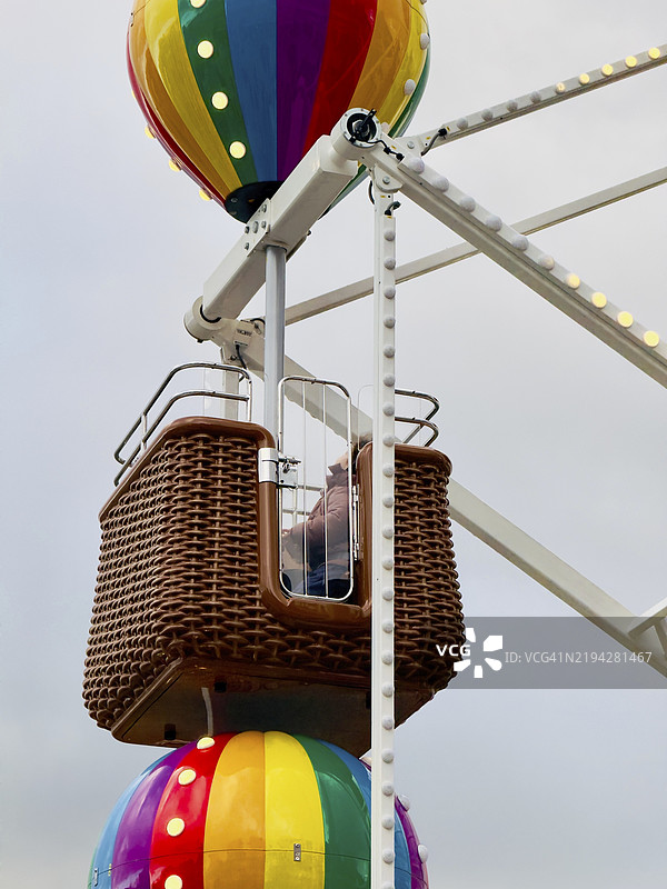 伊斯坦布尔摩天轮的藤制座椅特写，背景是五彩缤纷的热气球图片素材