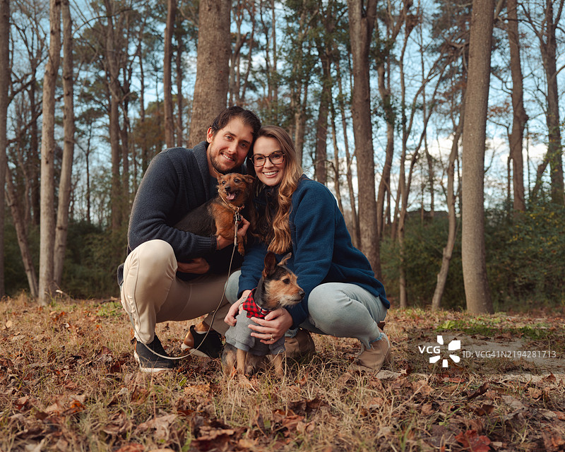 秋冬季节情侣肖像与小狗 - 森林 - 膝盖跪地图片素材
