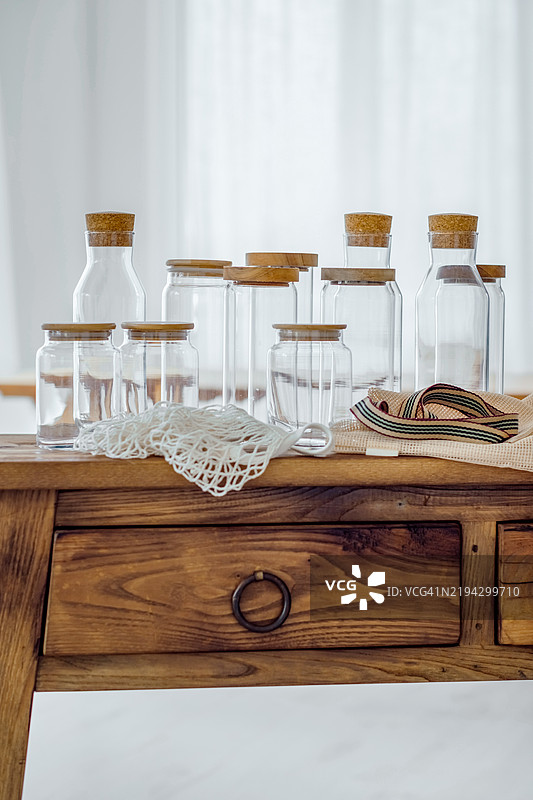 环保理念。木桌上的纺织环保袋和空玻璃罐。图片素材