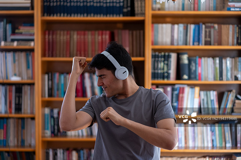 年轻学生在图书馆里跳舞并听音乐图片素材