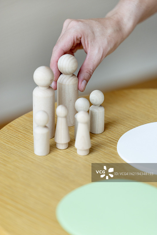 家庭星座由木质棋子玩偶在心理咨询师的辅导会议上象征。图片素材