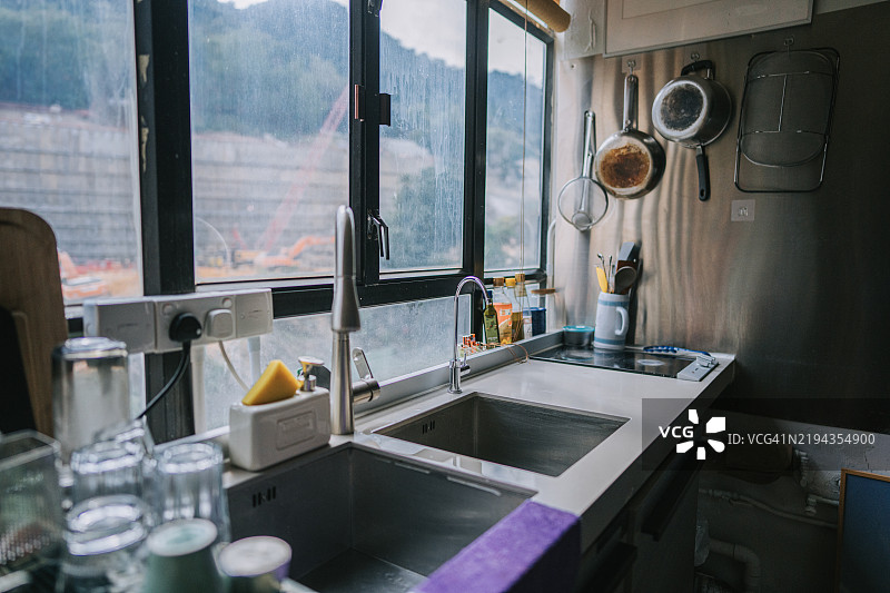 香港公寓内有窗户的厨房水槽，阳光自然洒入。图片素材