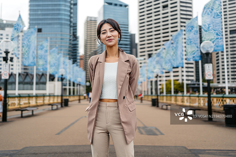 年轻的亚洲女商人在澳大利亚悉尼的达令港站立图片素材