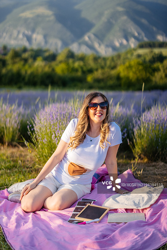 中年孕妇坐在薰衣草田里图片素材