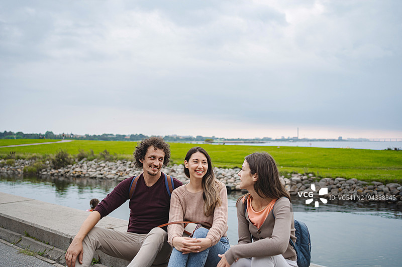 学生们在瑞典马尔默的运河旁放松聊天图片素材
