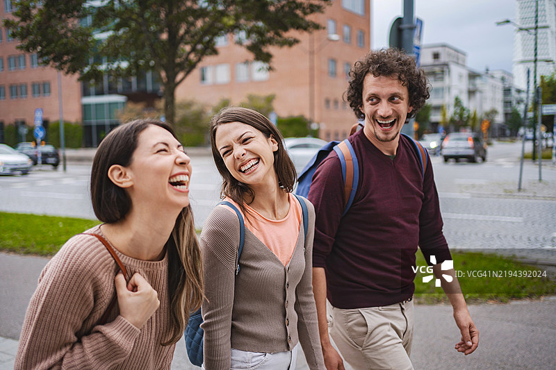 三个快乐的学生在马尔默一起走路欢笑图片素材