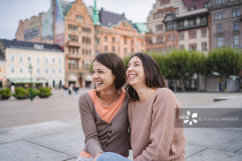 两个微笑的游客在马尔默一起欢笑图片素材