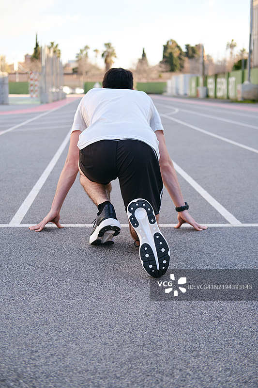 年轻运动员在跑道上准备跑步。无法识别的人。概念：健康生活方式与运动图片素材