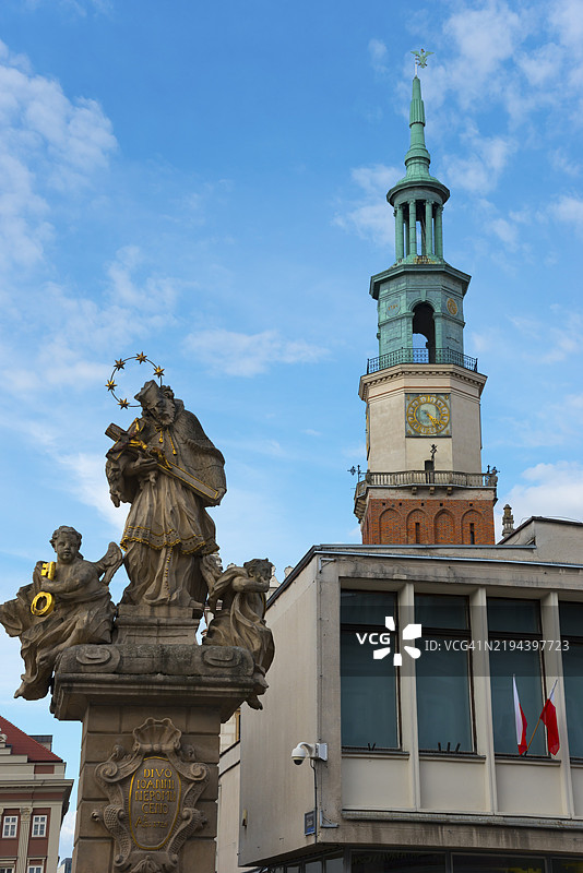 历史雕像与教堂塔楼在清澈蓝天的背景下，圣约翰·内波穆克雕像和市政厅，波兹南市场广场，波兹南，波兰大波兰省，欧洲图片素材