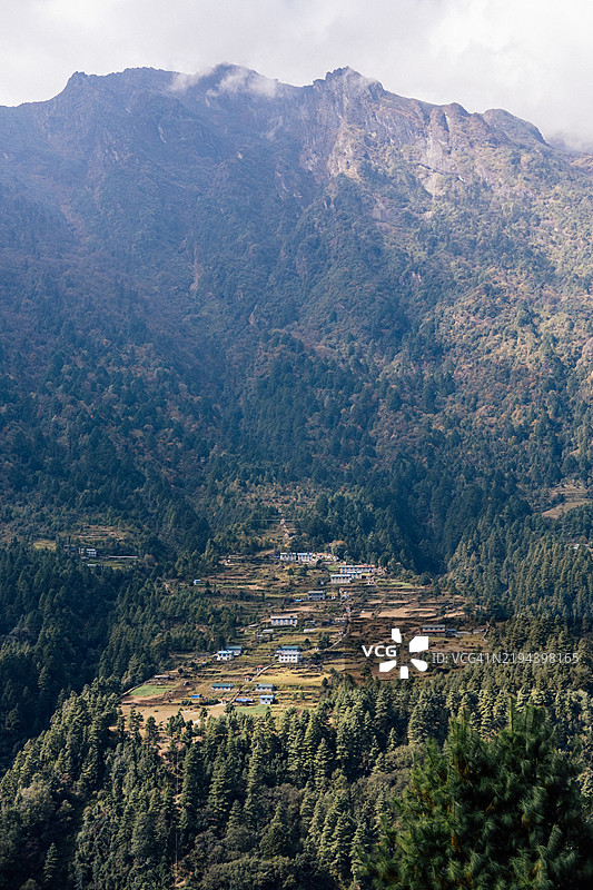 尼泊尔山地风景的广角镜头，山上有一个小村庄。图片素材