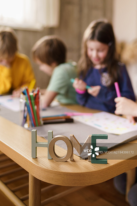 “家”字标志与背景中的儿童画作图片素材