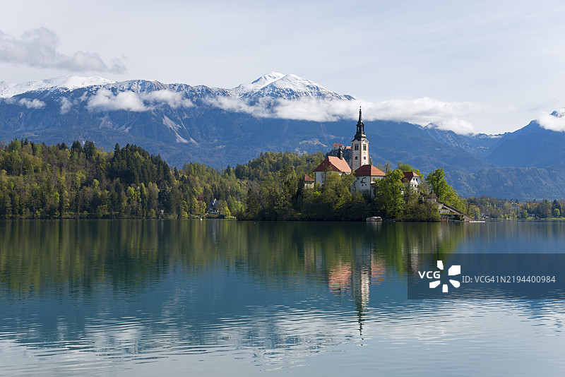 岛上的教堂倒映在宁静的湖面上,背景是山景,布莱德岛上的圣玛丽教堂,布莱德湖,维尔德斯湖,上卡尔尼奥拉地区,戈伦斯卡,斯洛文尼亚,巴尔干,欧洲图片素材
