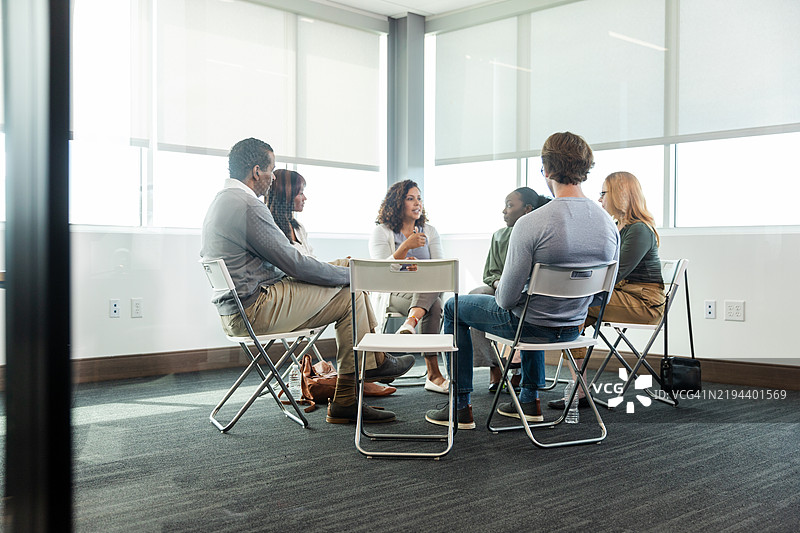 团体治疗会议：多元化的成年人围坐在一起图片素材