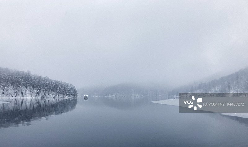 克罗地亚普利特维采湖泊的冬季景观，针叶林倒映在湖面上图片素材