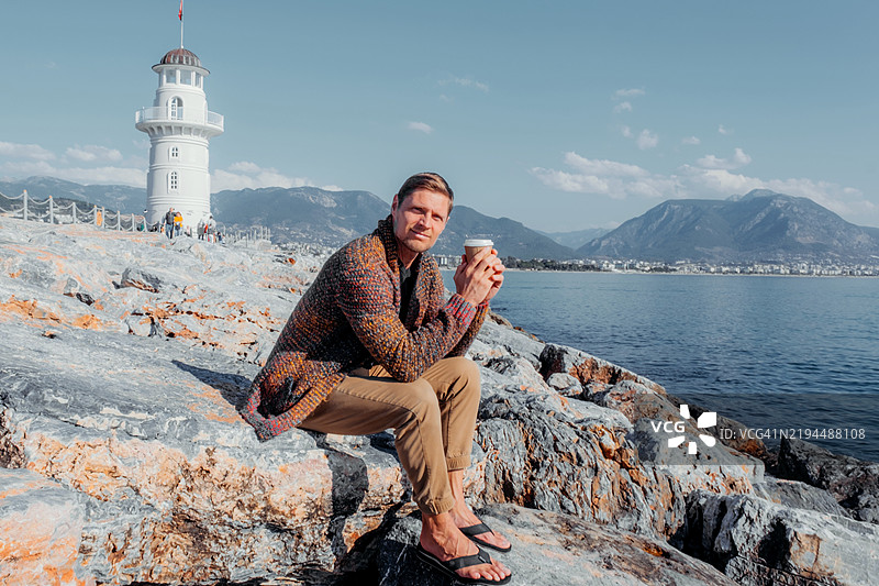 灯塔旁的海岸放松景观，远处有山景图片素材