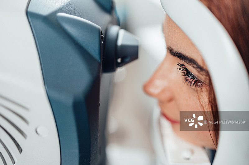 美丽的年轻女性正在接受眼科治疗。眼科医生使用现代设备检查她的视力。图片素材