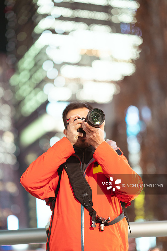 夜晚街头的摄影师与数码相机图片素材