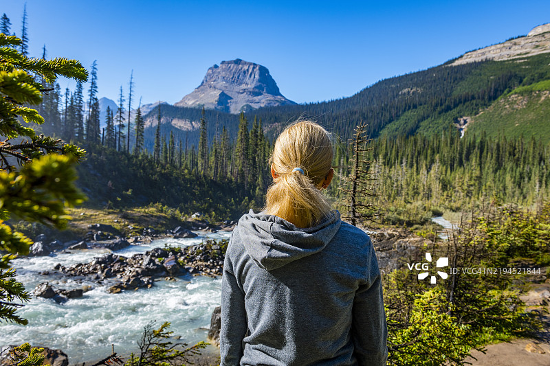 一位女性在加拿大不列颠哥伦比亚省的雅霍河旁凝视。图片素材
