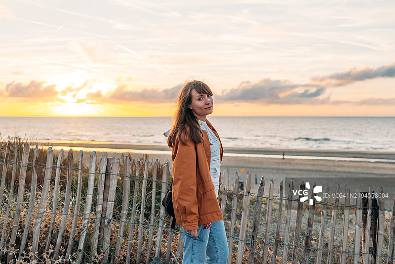 年轻女性在北海享受日落图片素材