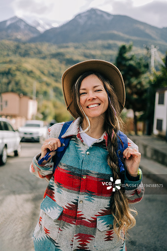 微笑的游客在公路旅行中欣赏山景图片素材