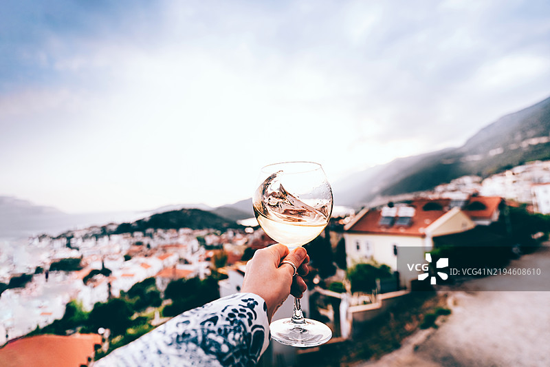 一位女性在日落时享受香槟的第一人称视角图片素材