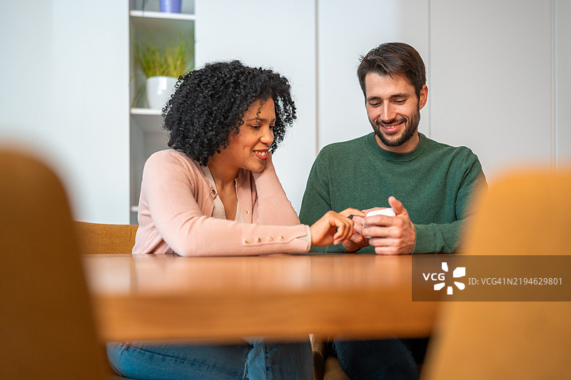 多元化情侣在家中调节智能温控器图片素材