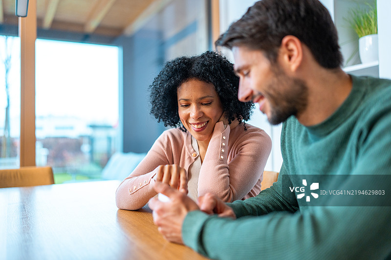 多元化情侣一起调节家中的温控器图片素材