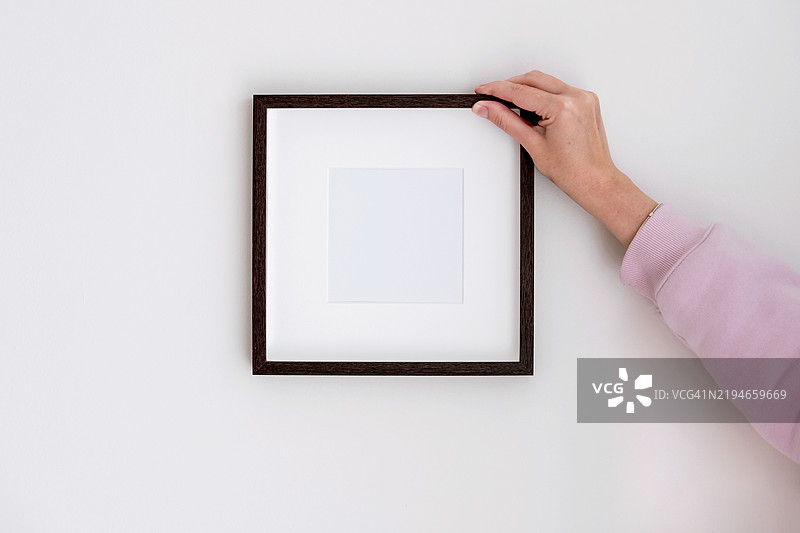 简约的墙面装饰，手持方形框架 - 适合现代室内设计。图片素材