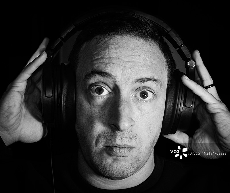 戴着耳机的男人，惊讶的表情图片素材