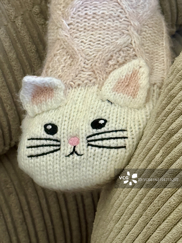 手工编织的女孩长袜，近距离展示猫脸刺绣设计图片素材