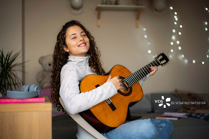 一个少女躺在她的房间床上阅读，享受着。图片素材