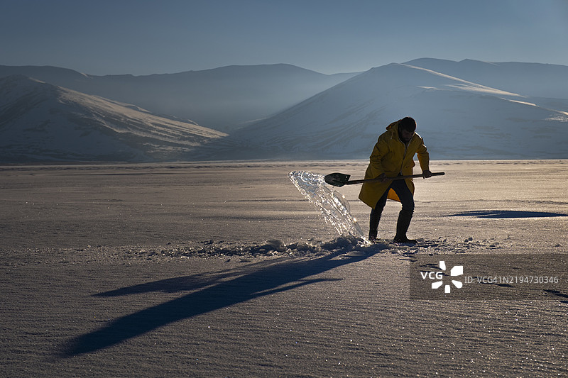 科学家在冰冻湖面上移除冰层进行研究图片素材