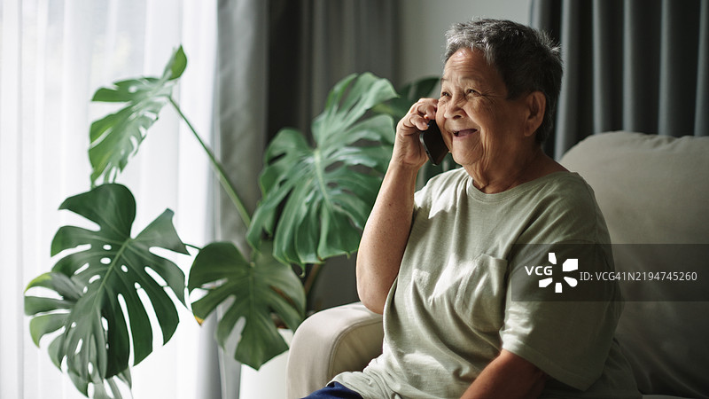 老年女性在使用智能手机通话。图片素材