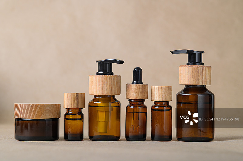 一组带木盖的琥珀玻璃瓶，背景为中性色调图片素材